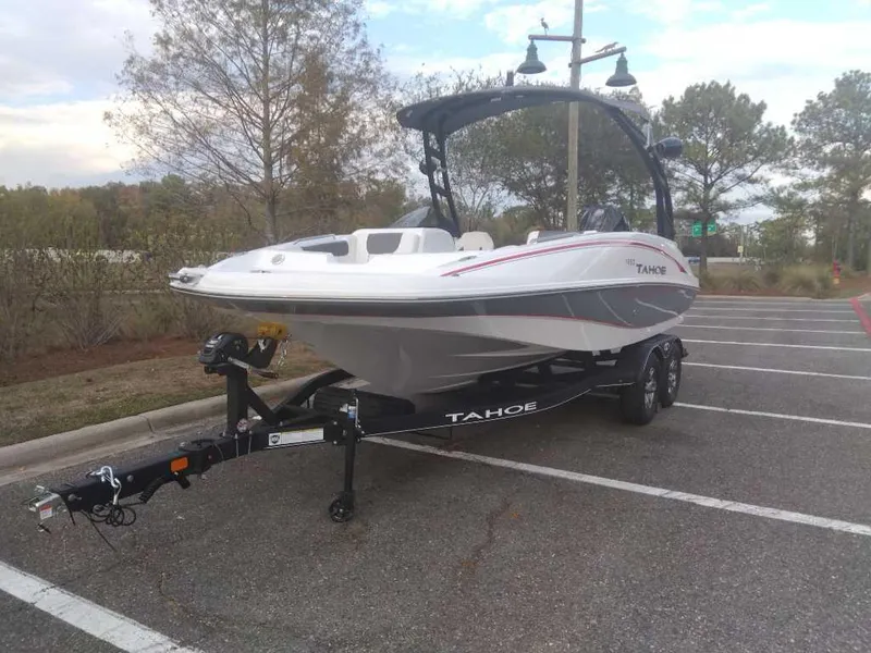 Slide: The Image of 2023 Tahoe 1950 boat on a trailer in a parking lot. - 2