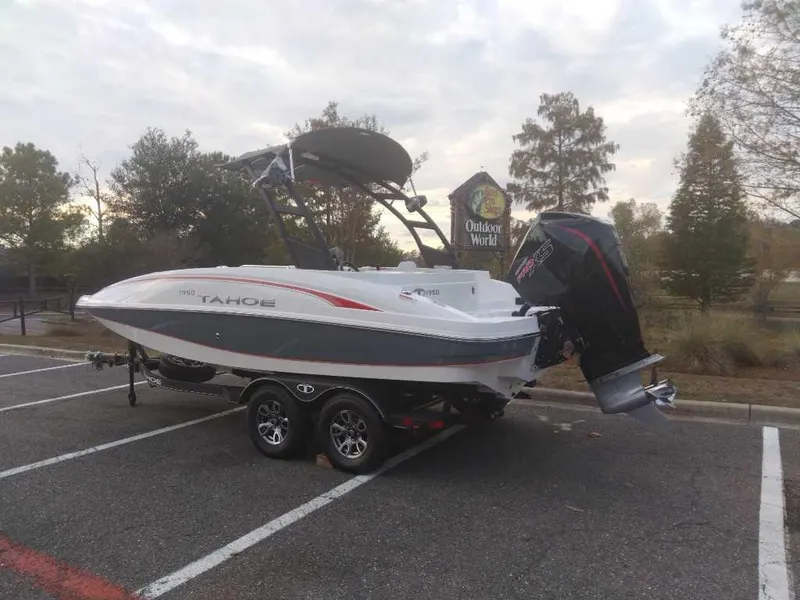 Slide: The Image of 2023 Tahoe 1950 boat on trailer in parking lot near Outdoor World. - 3