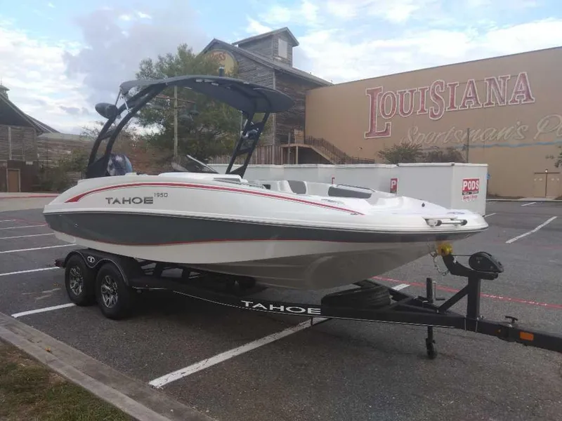 Slide: The Image of 2023 Tahoe 1950 boat on trailer in parking lot near Louisiana Sportsman's Paradise sign. - 8