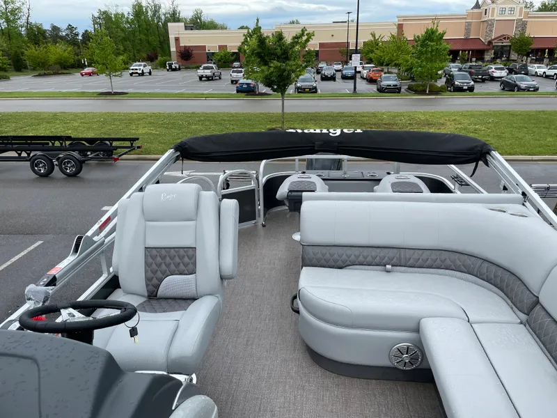 Slide: The Image of 2023 Ranger 223F pontoon boat with gray seating and black canopy in parking lot. - 5