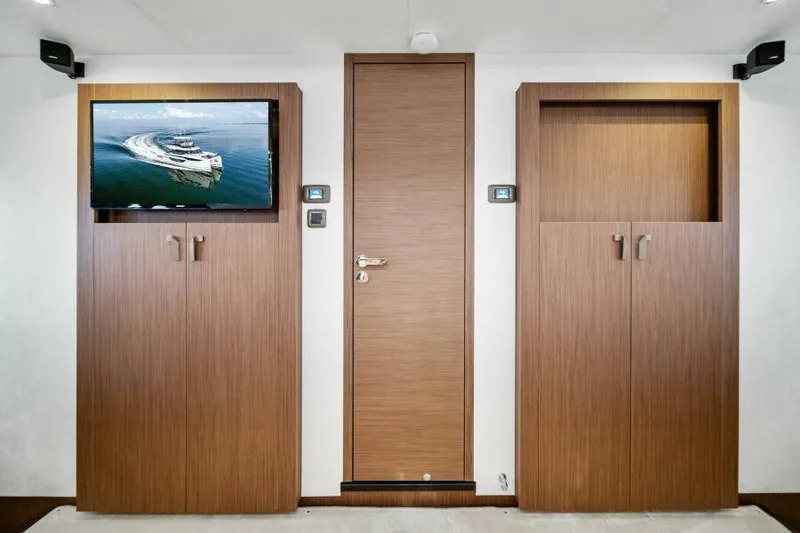 Slide: The Image of Interior of Prestige M48 yacht, featuring modern wood paneling and a mounted TV, 2025 model. - 38