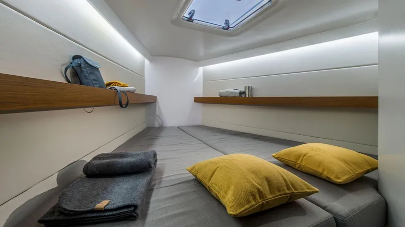 Slide: The Image of Beneteau First 36 2024 yacht interior cabin with cozy bedding and modern design. - 10