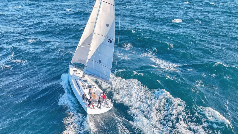 Slide: The Image of 2024 Beneteau First 36 sailboat navigating through open waters. - 2