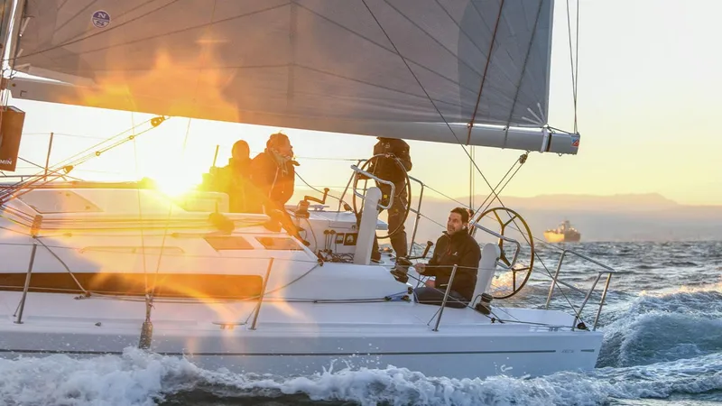 Slide: The Image of 2024 Beneteau First 36 sailboat cruising at sunset with crew onboard. - 5