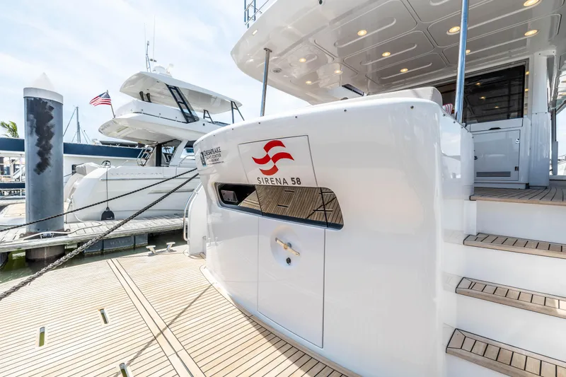 Slide: The Image of 2025 Sirena 58 yacht docked at marina with American flag in background. - 11