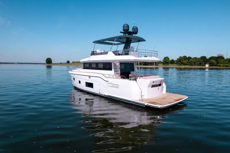 Slide: The Image of 2025 Sirena 58 yacht cruising on a calm lake under a clear blue sky. - 2