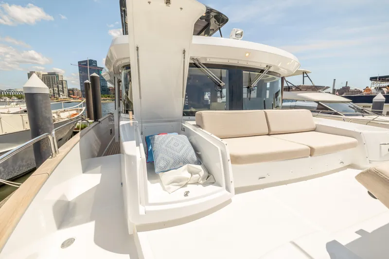 Slide: The Image of 2025 Sirena 58 yacht with spacious deck and comfortable seating at a marina. - 24