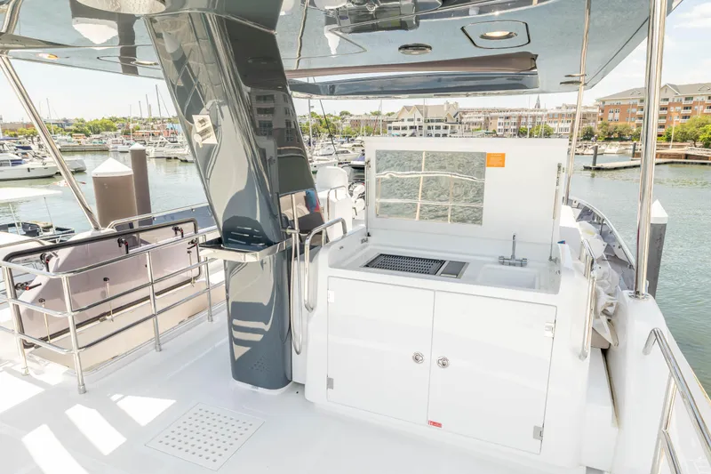 Slide: The Image of Luxury Sirena 58 yacht deck with outdoor kitchen, marina view, 2025 model. - 31