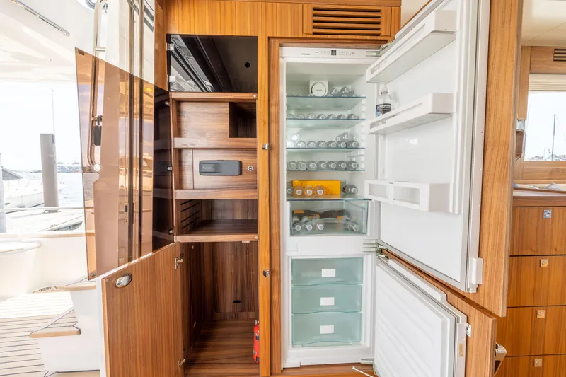 Slide: The Image of Open refrigerator and storage cabinets on Sirena 58 yacht, 2025 model. - 35