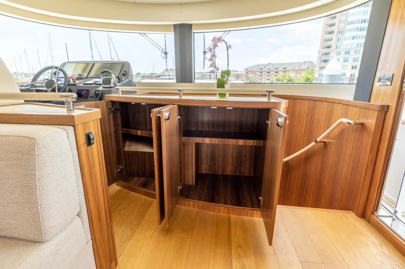 Slide: The Image of Interior of 2025 Sirena 58 yacht with open wooden cabinets and panoramic windows. - 42