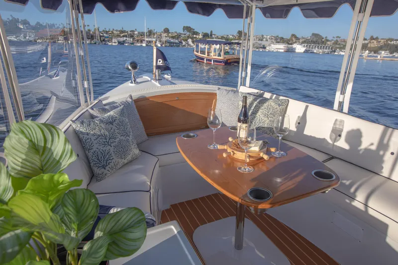 Slide: The Image of Interior of 2022 Duffy Snug Harbor 18 boat with table, wine, and scenic water view. - 3