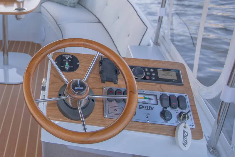 Slide: The Image of 2022 Duffy Snug Harbor 18 boat helm with wooden steering wheel and control panel. - 5