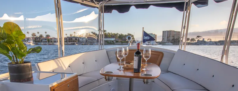 Slide: The Image of Interior of 2022 Duffy Snug Harbor 18 boat with wine and glasses on table. - 6