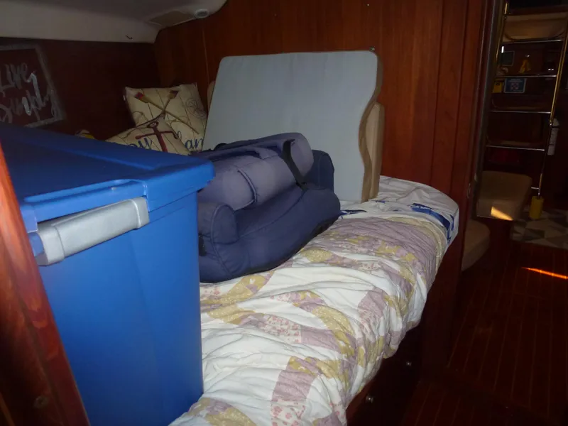 Slide: The Image of Interior cabin of a 2001 Hunter 420 Passage sailboat with storage items on bed. - 14
