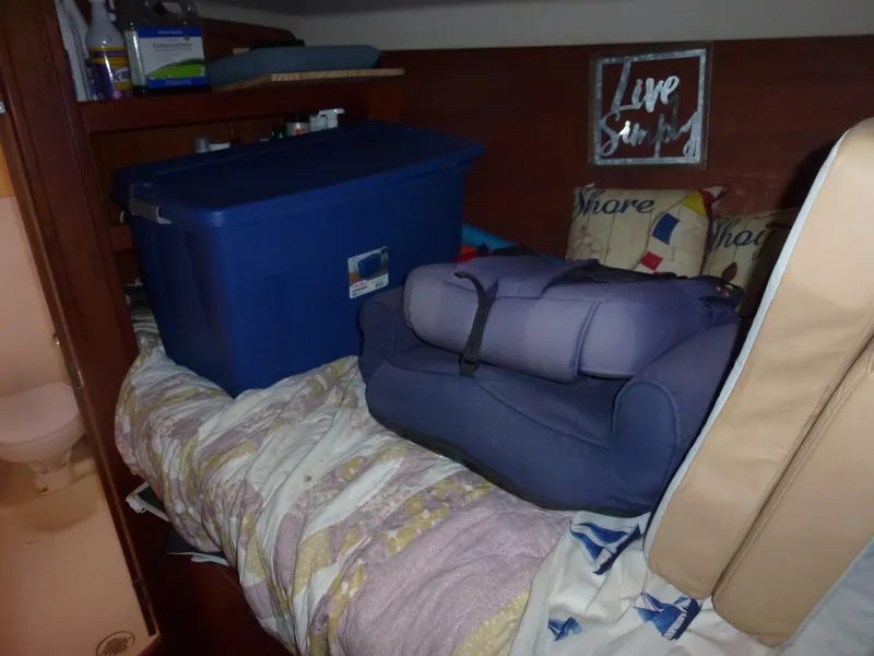 Slide: The Image of Interior of 2001 Hunter 420 Passage with storage containers on bed. - 16
