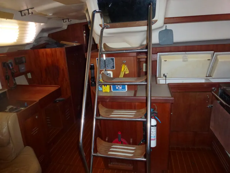 Slide: The Image of Interior of 2001 Hunter 420 Passage sailboat with wooden cabinetry and stainless steel ladder. - 21