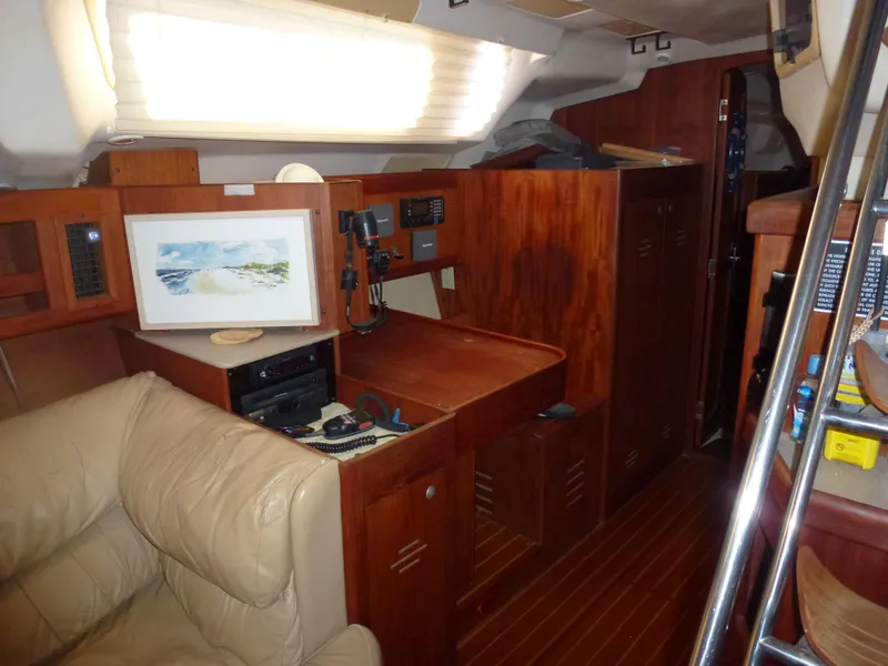 Slide: The Image of Interior of a 2001 Hunter 420 Passage sailboat with wooden cabinetry and beige seating. - 23