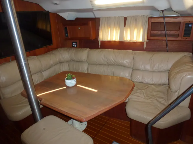 Slide: The Image of Interior of 2001 Hunter 420 Passage sailboat with leather seating and wooden table. - 24