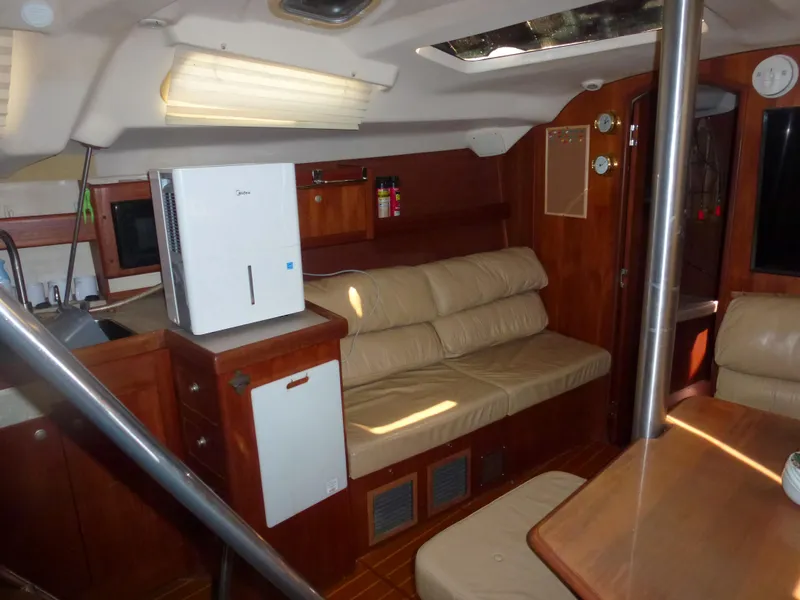 Slide: The Image of Interior of 2001 Hunter 420 Passage sailboat with beige seating and wooden cabinetry. - 25