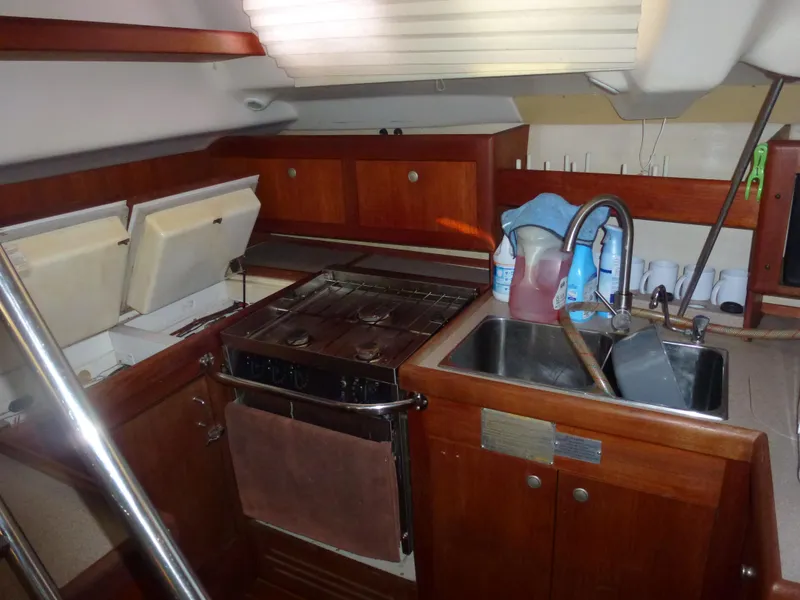 Slide: The Image of 2001 Hunter 420 Passage yacht kitchen with stove, sink, and wooden cabinets. - 26