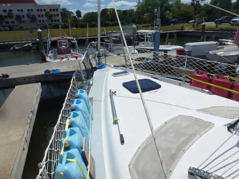 Slide: The Image of 2001 Hunter 420 Passage sailboat docked at marina with safety netting and water jugs. - 4