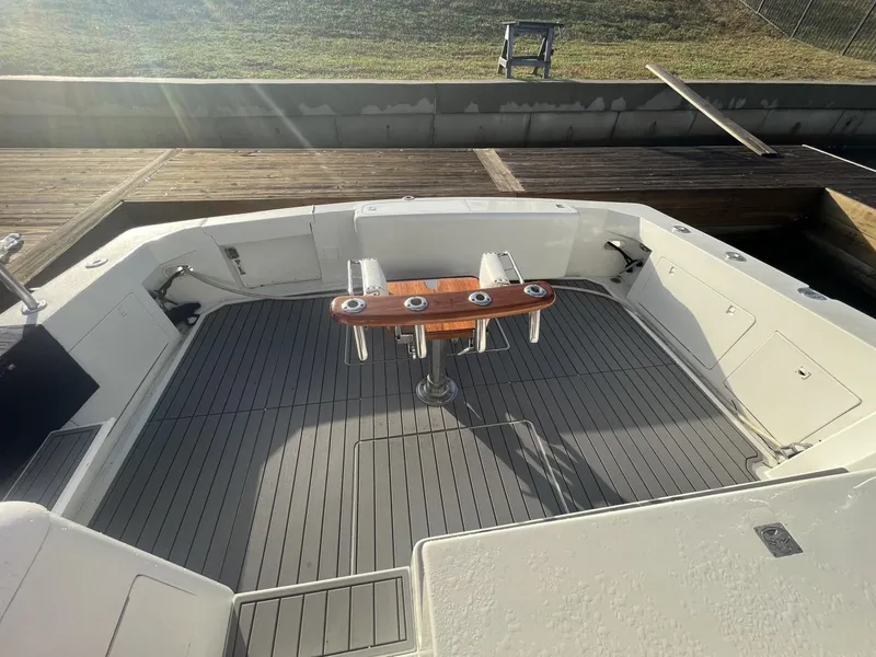 Slide: The Image of 1993 Bertram 46 Moppie boat deck with fishing rod holders and wooden trim. - 15