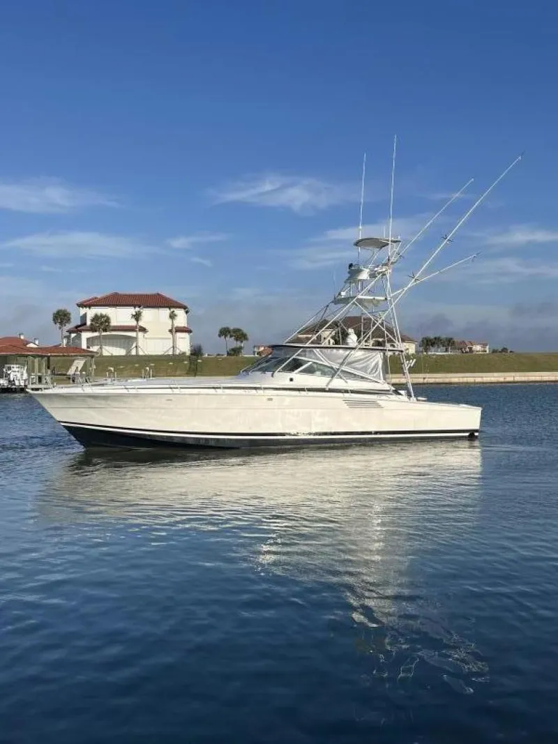 Slide: The Image of 1993 Bertram 46 Moppie boat on calm water with a clear sky background. - 22