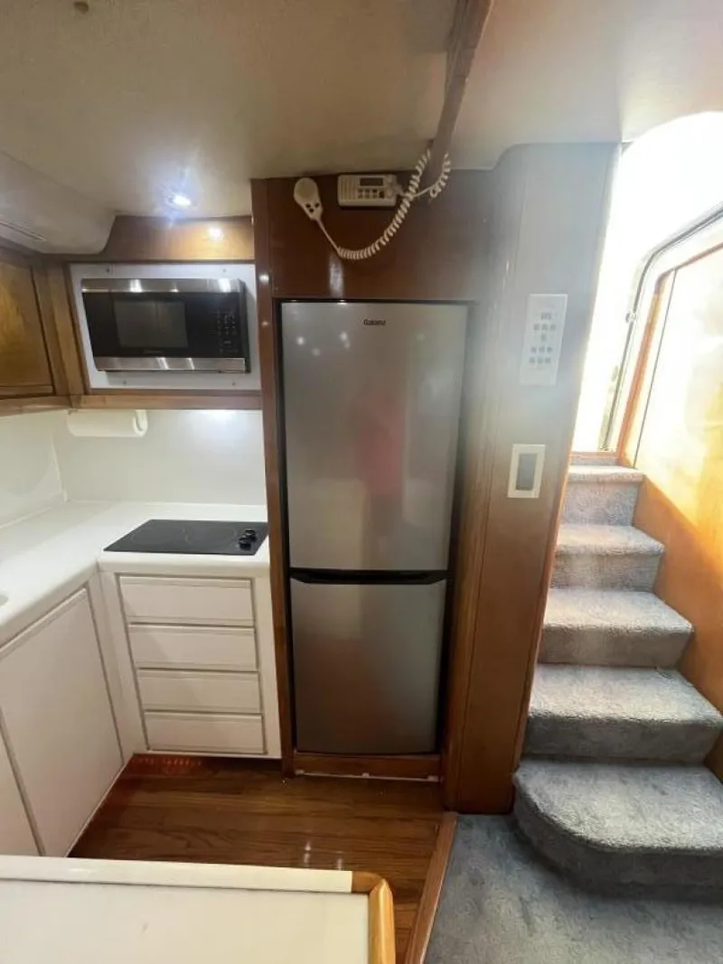 Slide: The Image of 1993 Bertram 46 Moppie yacht kitchen with microwave, fridge, and stairs. - 6