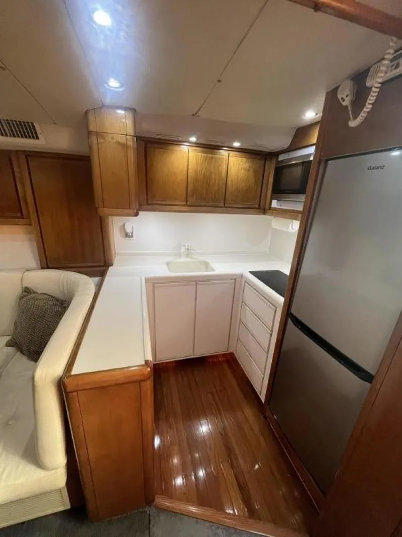 Slide: The Image of 1993 Bertram 46 Moppie yacht kitchen with modern appliances and wooden cabinetry. - 7