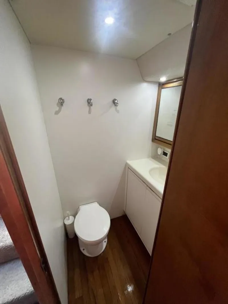 Slide: The Image of 1993 Bertram 46 Moppie yacht bathroom with toilet, sink, and mirror. - 8