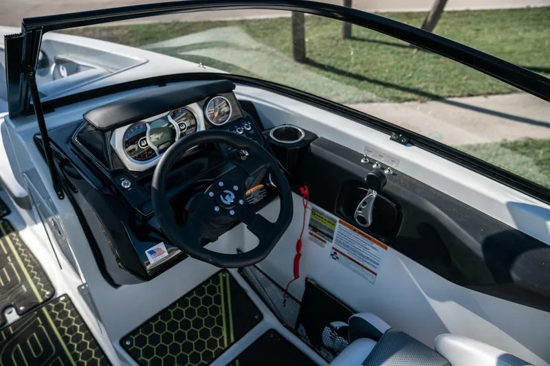 Slide: The Image of 2022 Scarab 255 boat cockpit with steering wheel and dashboard controls. - 10