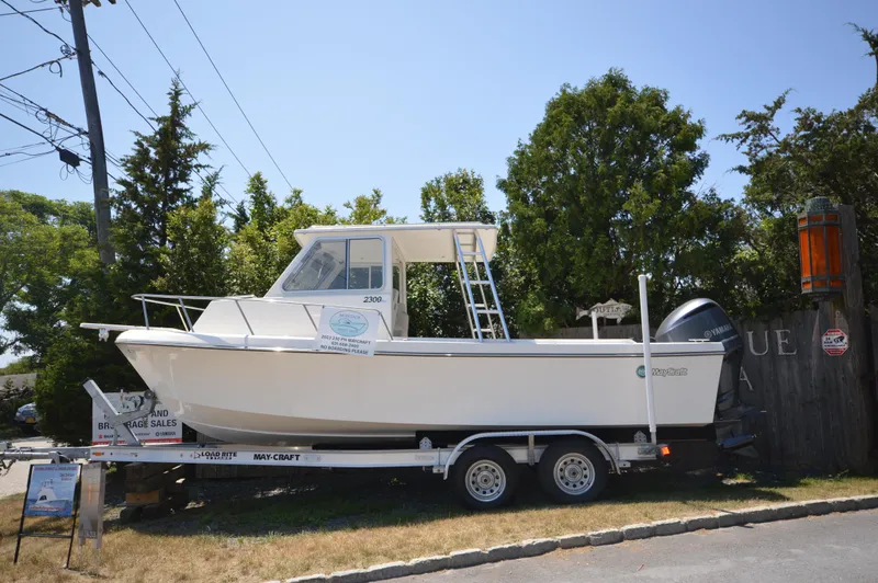 The Image of 2023 May-Craft 23 Pilothouse boat on a trailer, displayed outdoors. - 0