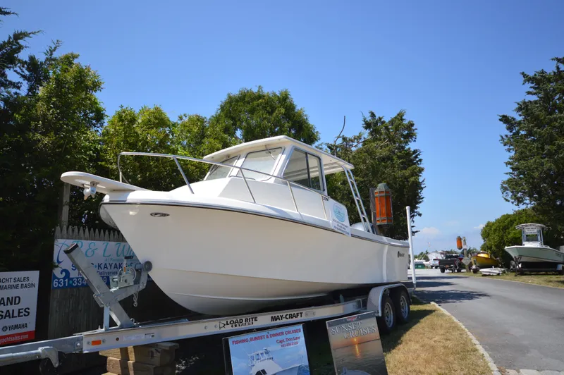 Slide: The Image of 2023 May-Craft 23 Pilothouse boat on trailer, displayed outdoors. - 1
