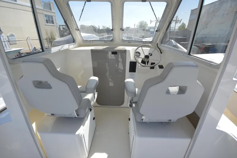 Slide: The Image of 2023 May-Craft 23 Pilothouse interior with dual seats and steering wheel. - 9