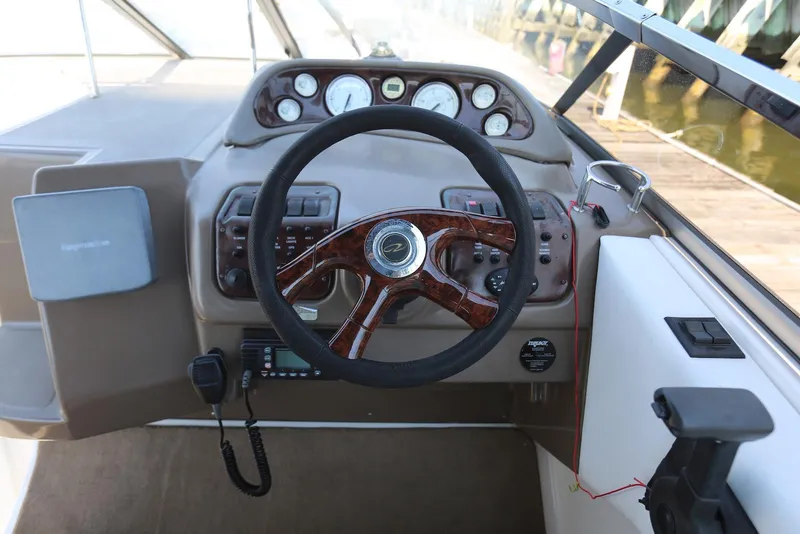 Slide: The Image of 2005 Regal Commodore 2665 boat dashboard with steering wheel and control panel. - 17