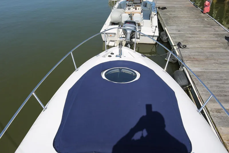 Slide: The Image of 2005 Regal Commodore 2665 boat docked, featuring a blue deck cover and railing. - 28
