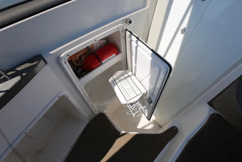 Slide: The Image of 2005 Regal Commodore 2665 boat interior with open storage compartment and fire extinguisher. - 31
