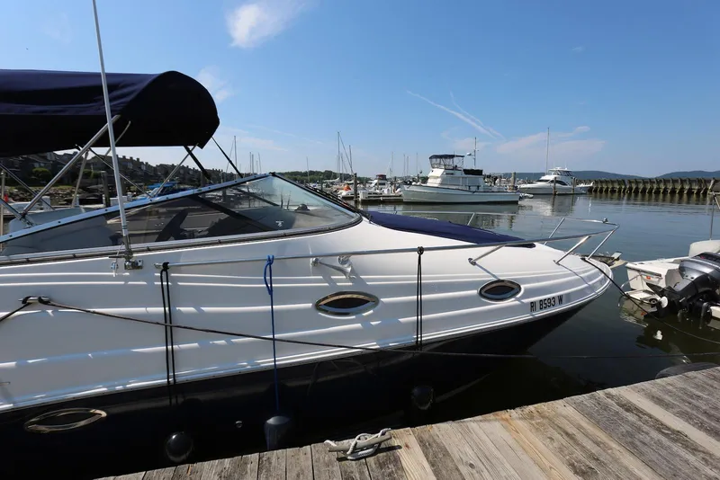 Slide: The Image of 2005 Regal Commodore 2665 boat docked at a marina under a clear blue sky. - 4