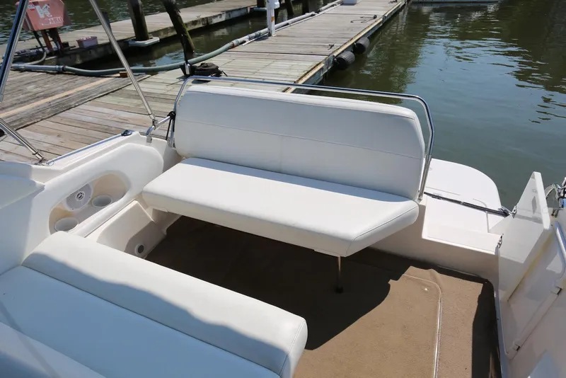 Slide: The Image of 2005 Regal Commodore 2665 boat interior with white seating and dock view. - 48