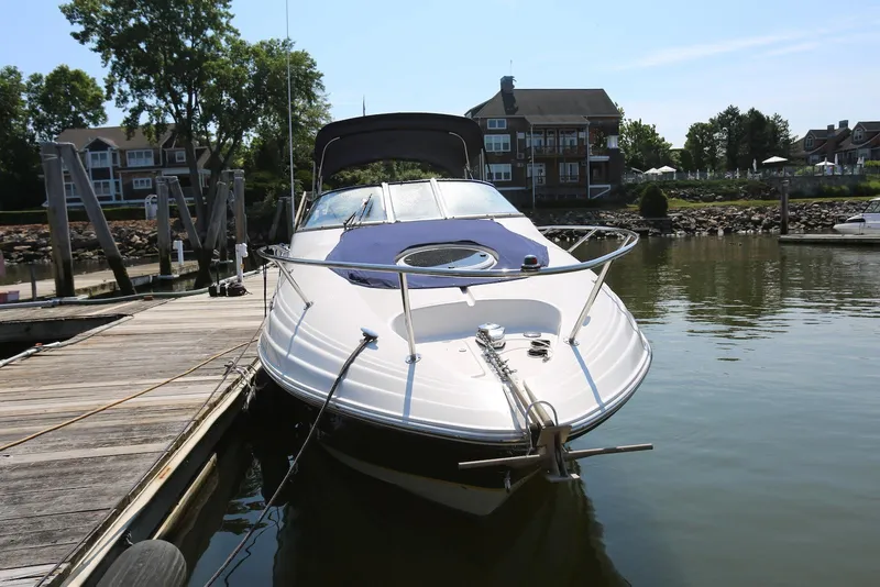 Slide: The Image of 2005 Regal Commodore 2665 boat docked at a marina with waterfront homes in the background. - 6