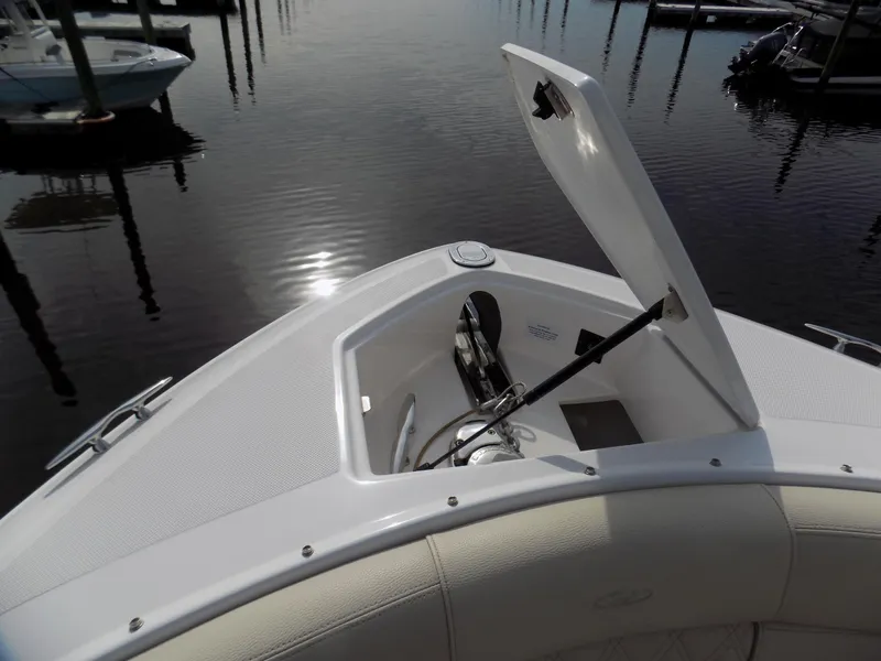 Slide: The Image of 2019 Regal 2800 Bowrider boat with open storage compartment, docked on calm water. - 8