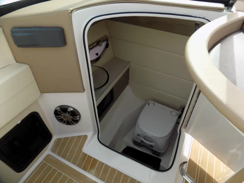 Slide: The Image of 2019 Regal 2800 Bowrider boat interior with compact toilet and storage area. - 9