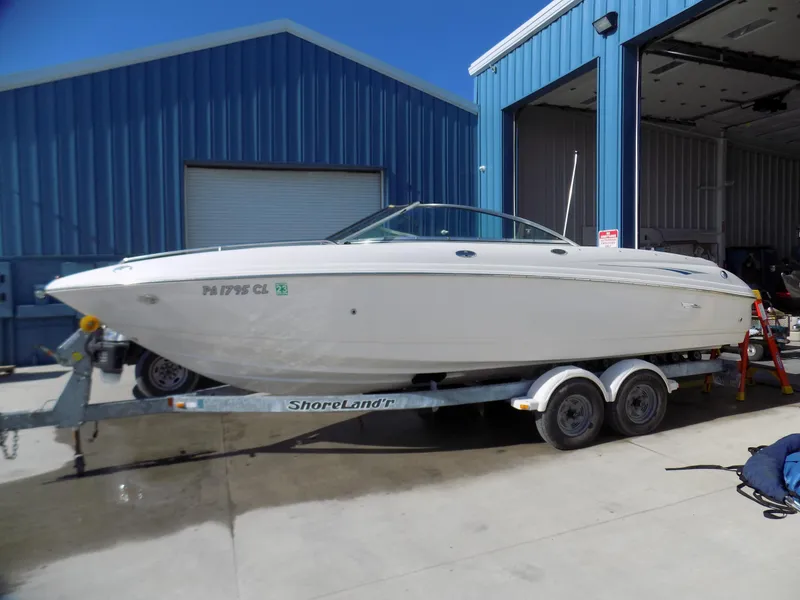 Slide: The Image of 2001 Chaparral 216 SSi boat on trailer outside blue warehouse. - 0