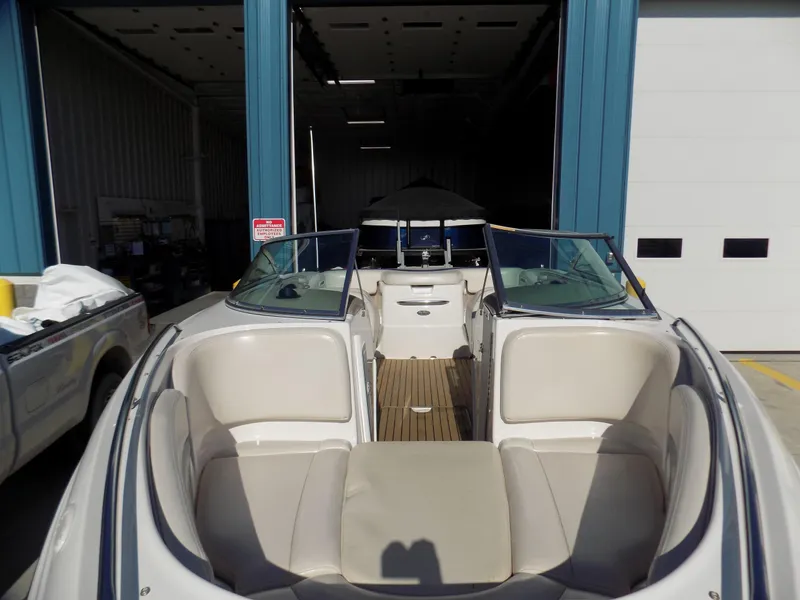 Slide: The Image of 2001 Chaparral 216 SSi boat with open bow seating, parked in a garage. - 1