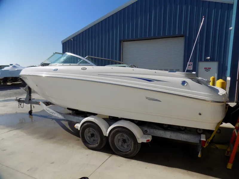 Slide: The Image of 2001 Chaparral 216 SSi boat on trailer near blue warehouse. - 2