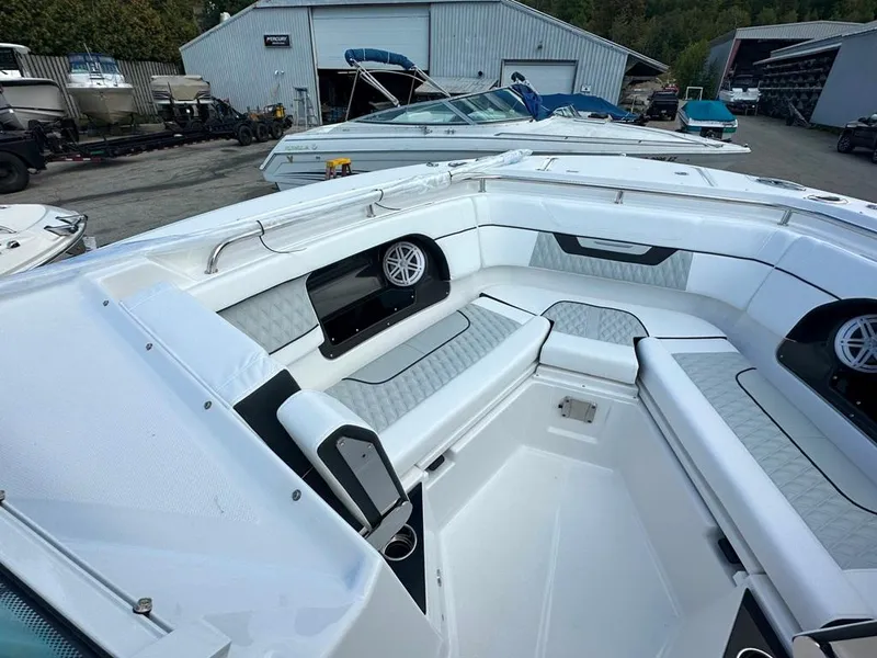 Slide: The Image of 2024 Blackfin 302 DC boat interior with seating and speakers in a marina. - 38