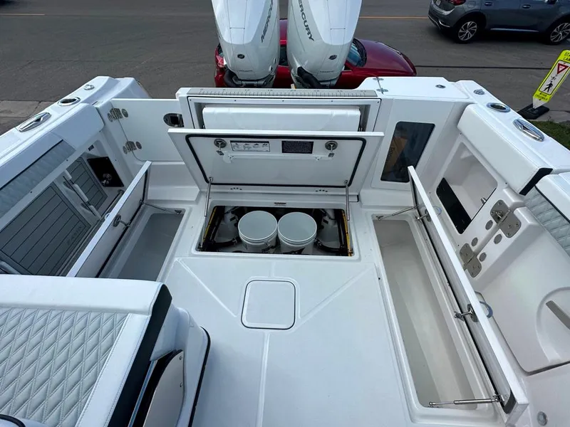 Slide: The Image of 2024 Blackfin 302 DC boat deck with storage compartments and twin outboard engines. - 9