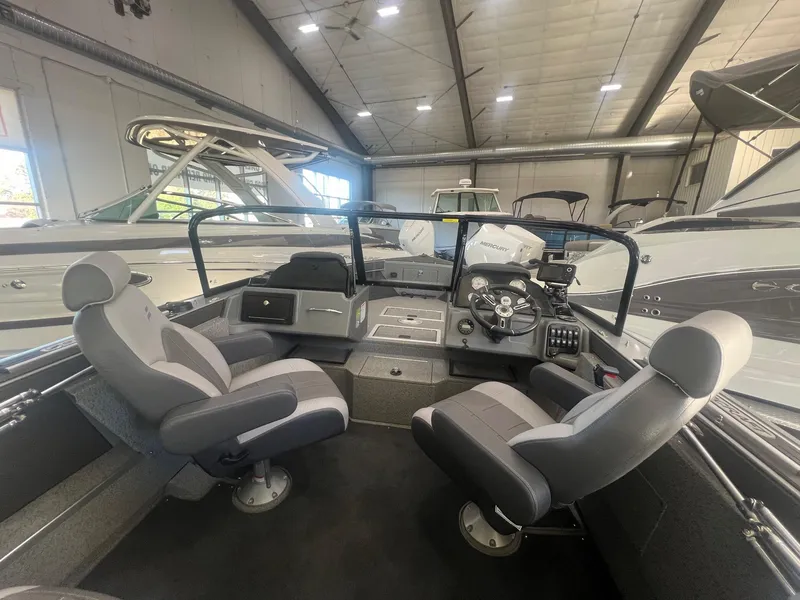 Slide: The Image of 2023 Starcraft Fishmaster 196 boat interior with dual seats and control panel in showroom. - 10