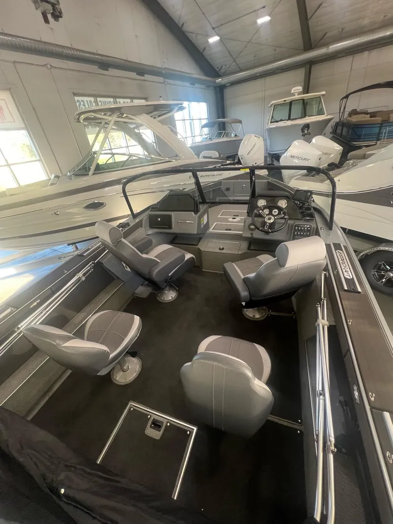 Slide: The Image of 2023 Starcraft Fishmaster 196 boat interior with seating and dashboard in showroom. - 2