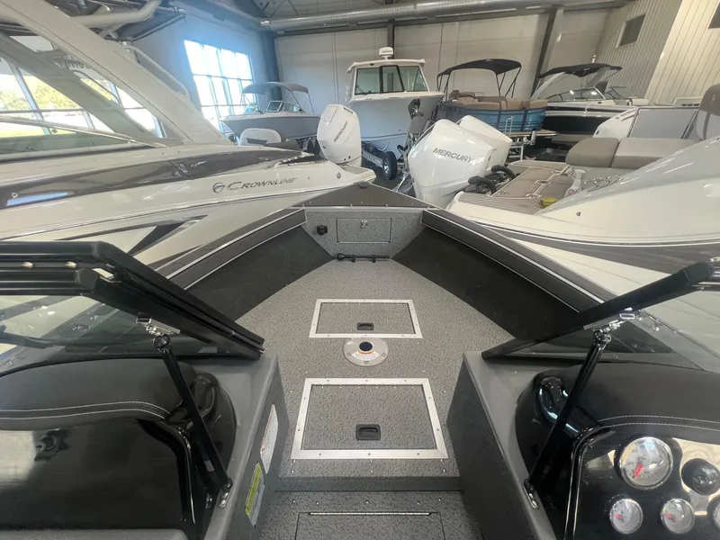 Slide: The Image of 2023 Starcraft Fishmaster 196 boat interior in showroom, featuring spacious deck and modern design. - 5